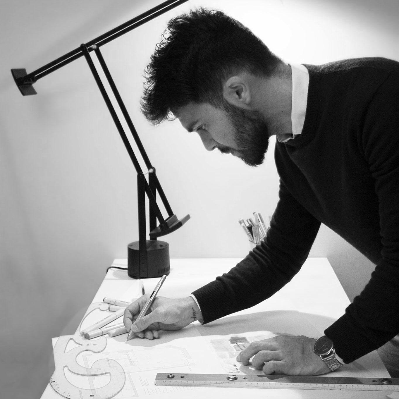 Designer Ragazzo con matita in mano che disegna su disegni tecnici